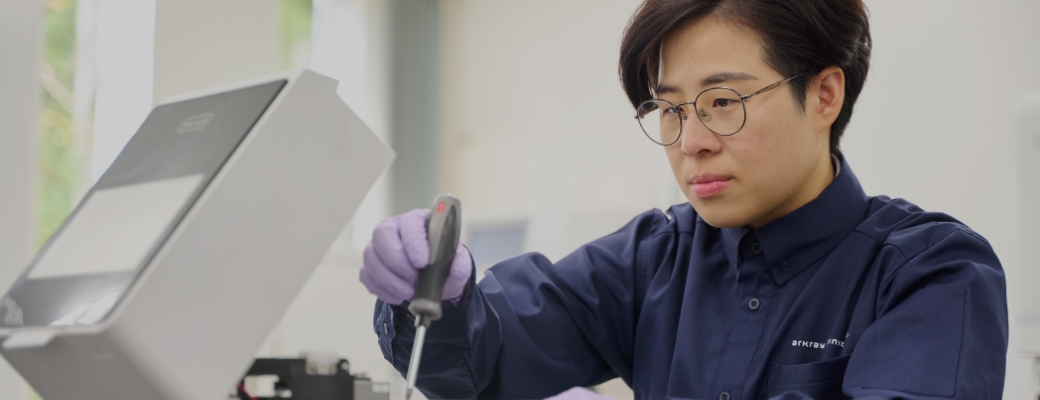 男女二人の検査員が検査装置で検査を行っている様子