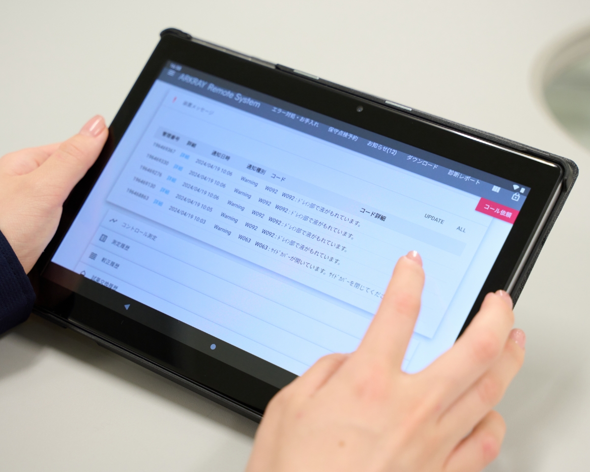 タブレットで装置の状態を確認している様子
